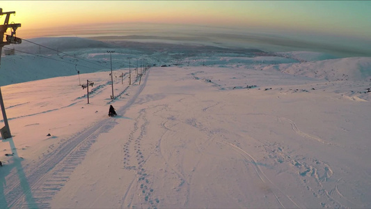 在滑雪胜地沿斜坡向下的雪地摩托视频