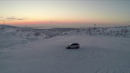 空中拍摄的熟练司机在雪地上做圆圈漂移视频