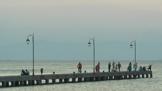 人们在黎明时沿着码头行走拍摄日常生活视频