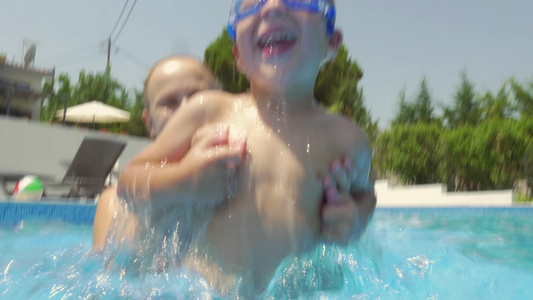小男孩和年轻母亲在游泳池里嬉戏视频