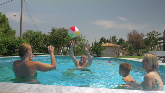 一家人在露天家庭游泳池玩充气气球游戏视频