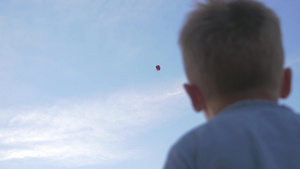 低角度拍摄的一个男孩挥舞着手望着空中的孔明灯7秒视频