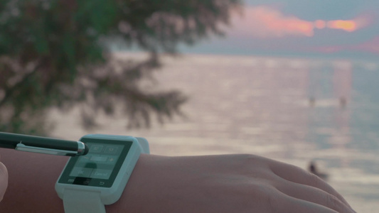 在海边笔触智能手表的特写镜头视频