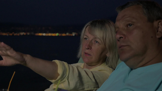 晚上在海边交谈的老年夫妇视频