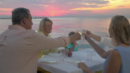 日落时大家庭在海边户外餐厅聚会视频