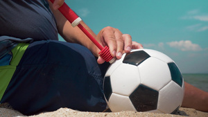 坐在海滩上给足球打球的男孩40秒视频