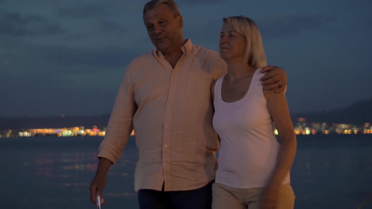 周年夫妇在傍晚的海滩边散步自拍视频