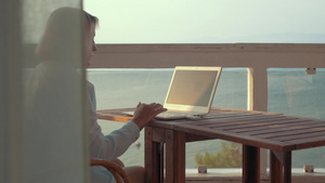 坐在户外阳台使用笔记本电脑的妇女31秒视频