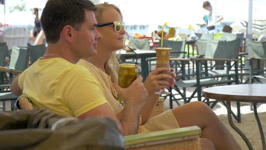 年轻男女坐在户外咖啡馆里喝冰咖啡[二十多岁]视频
