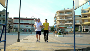 戴着耳机的成年父亲和儿子慢跑在度假城24秒视频