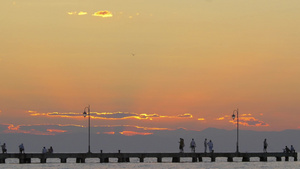 日落时人们在码头散步放松和钓鱼7秒视频