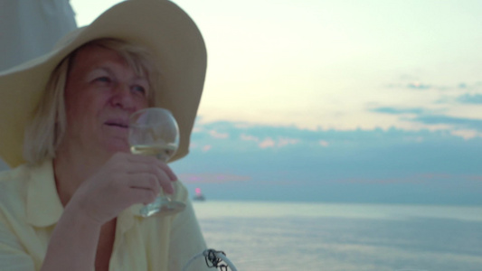日落老年夫妇在海边品尝喝饮料葡萄酒视频