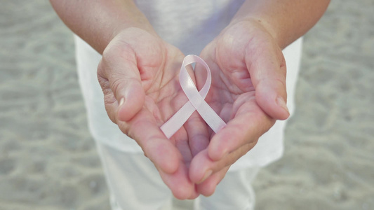 女性手握象征乳腺癌的粉红色丝带视频