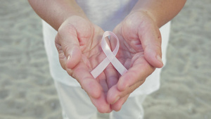 女性手握象征乳腺癌的粉红色丝带11秒视频