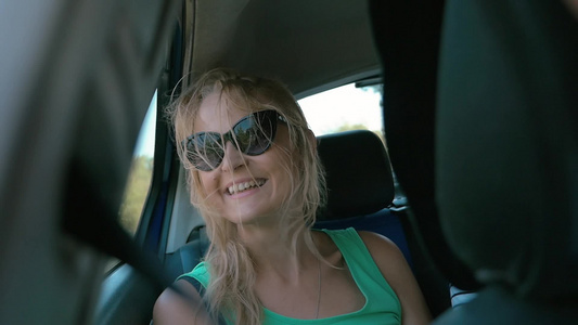 汽车后座上的一个戴着太阳镜的漂亮的女人视频