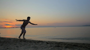 慢动作拍摄的年轻人在海滩上表演翻筋斗25秒视频