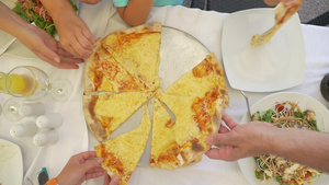 成人和儿童在餐厅晚餐时从托盘上拿奶酪比萨饼16秒视频