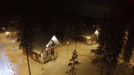 夜间在冬季松木中拍摄的客乡房屋视频