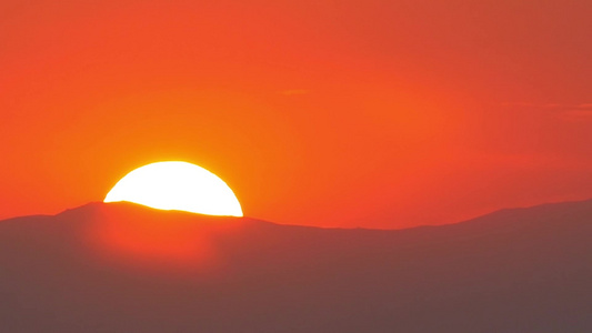 火红的大太阳落在一座山后面视频