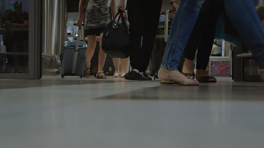 一群人带着行李走出机场航站楼的步履特写视频视频