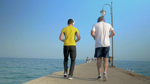 在海边倒着跑步的两个男人19秒视频