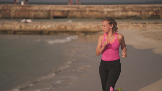 年轻的女孩在海滩上跑步视频