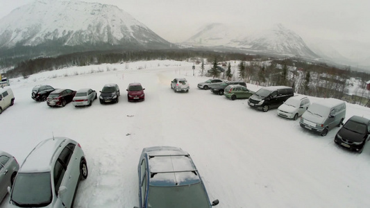 在冬季室外停车场一辆汽车沿着覆盖了雪的道路汽车行驶视频