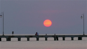 夕阳下的海面码头浮桥情侣依偎而坐59秒视频