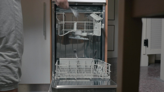 女人把脏盘子和餐具放进洗碗机[餐碟]视频