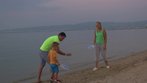 男孩和父母在海滩上玩打球的游戏9秒视频