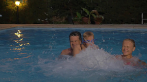 年轻夫妇和孩子晚上在游泳池里玩得很开心10秒视频