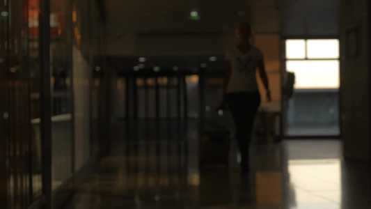 拖着行李箱的女人离开机场候机楼视频