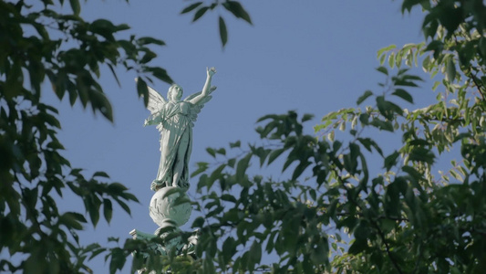透过绿色的树枝观看维多利亚雕像视频