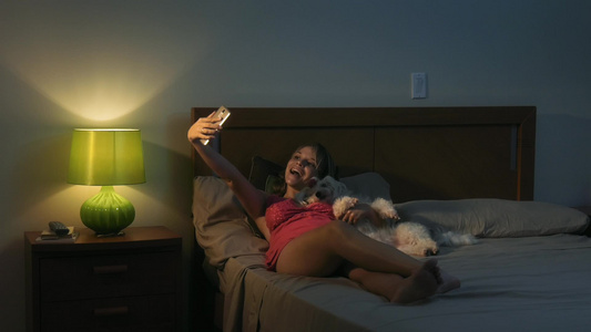 女人用手机拍为自己和宠物狗自拍视频