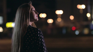 可爱的长发女人独自站在街上欣赏夜晚城市灯光的景观22秒视频