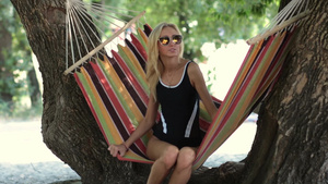 年轻美丽的女士在海滩边的吊床上放松休息17秒视频
