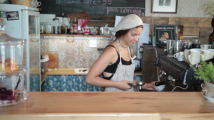 微笑的年轻咖啡师用专业的设备在咖啡馆里煮咖啡7秒视频