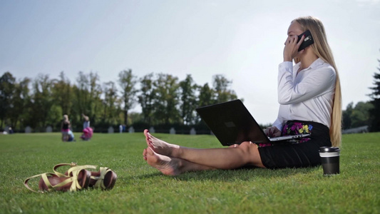 漂亮女商人赤脚坐在草坪操作电脑视频