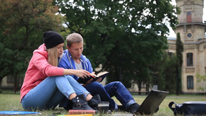 年轻的大学朋友坐在公园的校园草坪上一起学习看书15秒视频