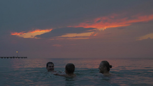 日落时年轻夫妇和小男孩在希腊佩雷亚市的海里游泳23秒视频