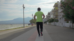 戴着耳机的年轻人在希腊佩雷亚市的路上跑步18秒视频