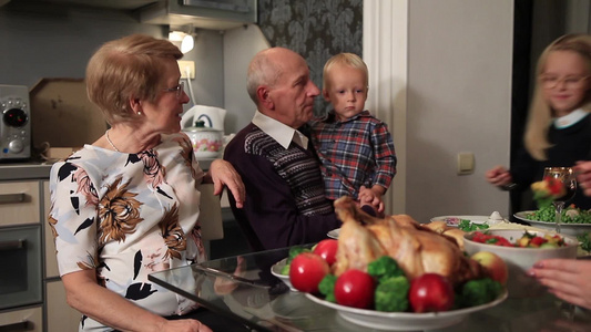 幸福的家庭和祖父母坐在节日的餐桌上庆祝感恩节视频