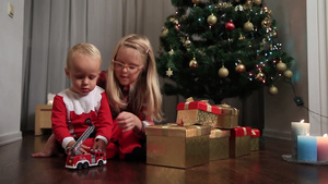 两个小朋友在圣诞树旁玩玩具20秒视频