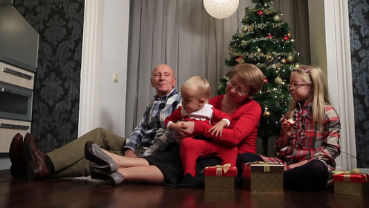 幸福的家庭坐在家里的圣诞树前视频