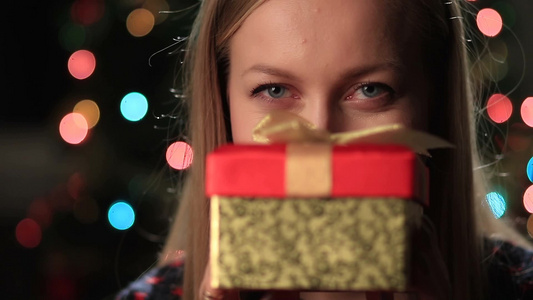 女孩微笑着拿着圣诞礼物盒视频