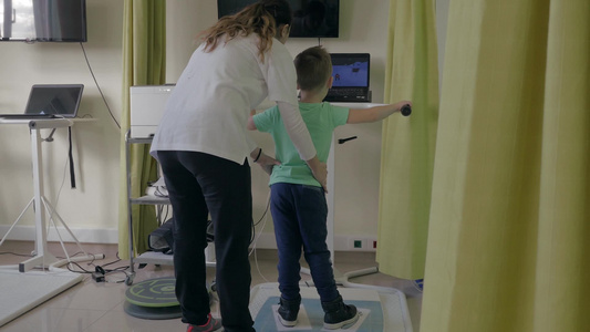 理疗诊所女医生运用特殊设备检查小男孩视频