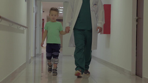 医生牵着男孩的手走在医院大厅10秒视频