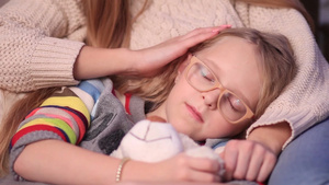 戴着眼镜的小女孩在妈妈的怀抱里睡着了12秒视频