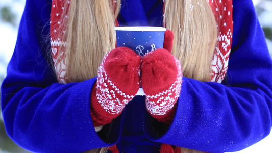 冬季户外女孩手捧热饮咖啡特写。视频