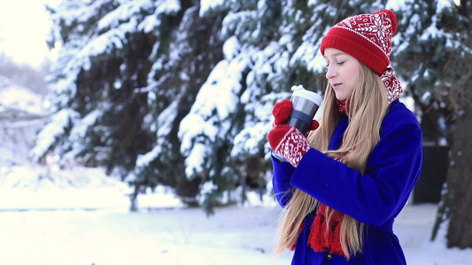 年轻迷人的女性在冬天的户外享受热饮视频